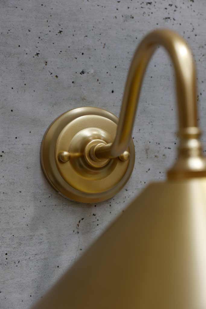 Close up on wall mounting plate in satin brass finish