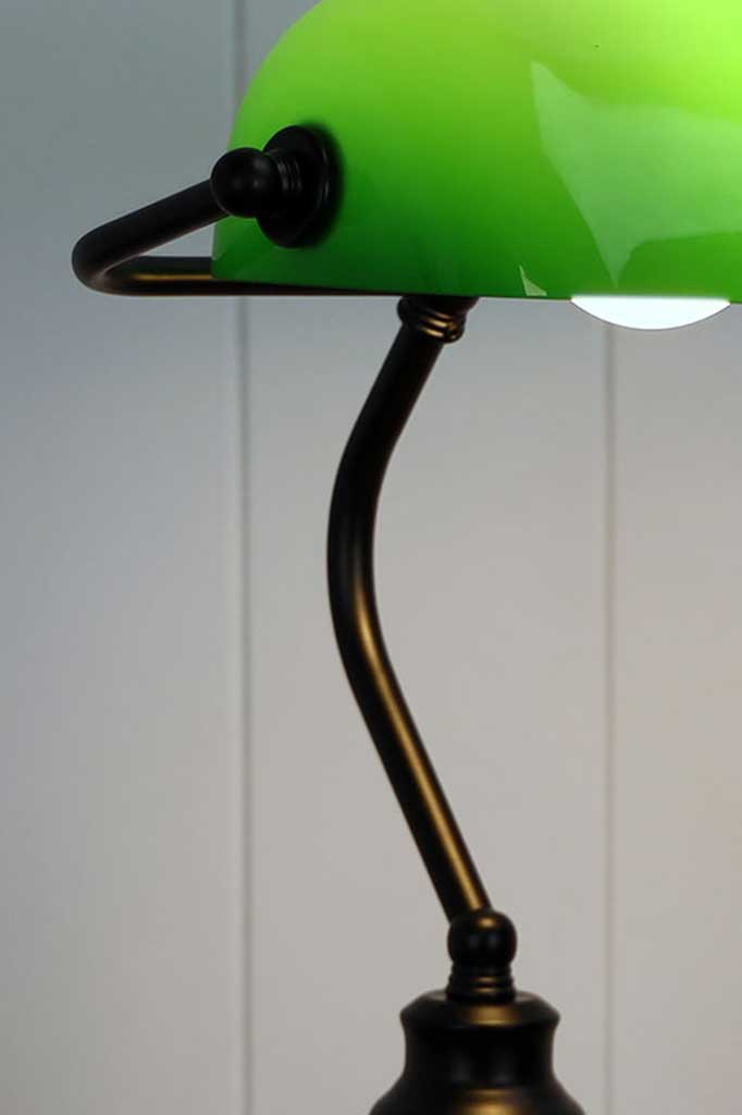 Close up of a Black Bankers lamp with green shade