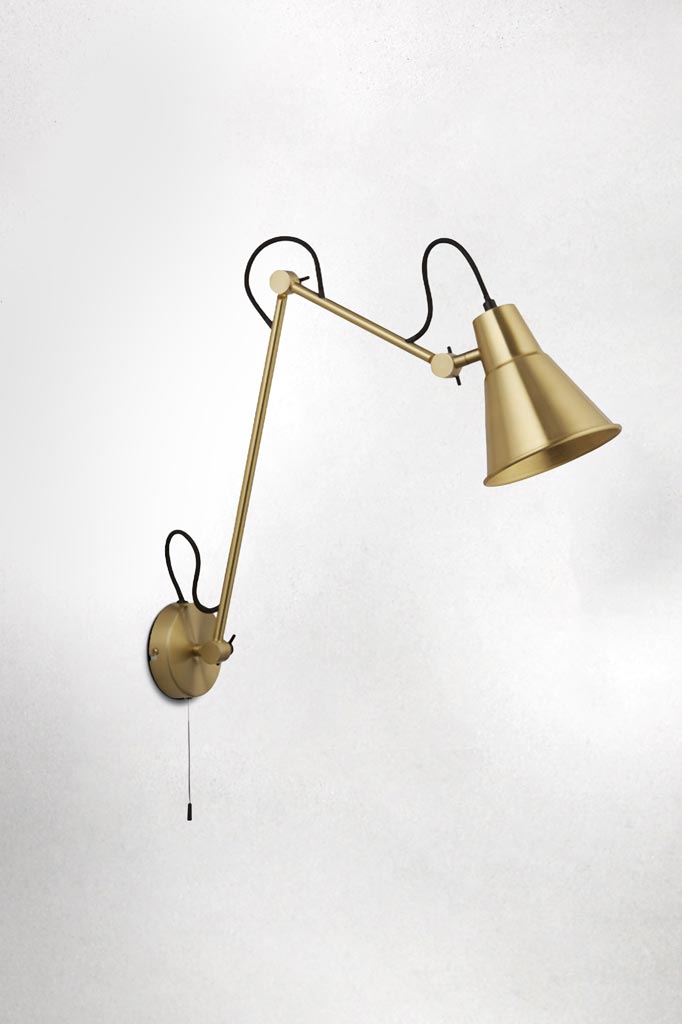 Brass metal wall light with adjustable arm and brass fixtures.