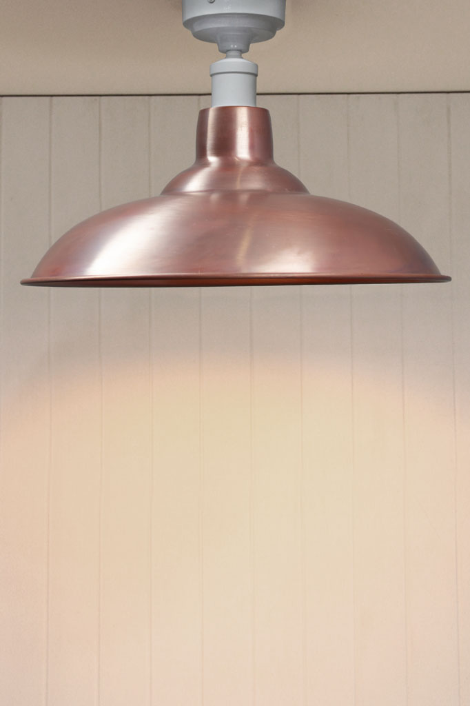 Aged solid copper barn shade on a white flush mount fixture. 