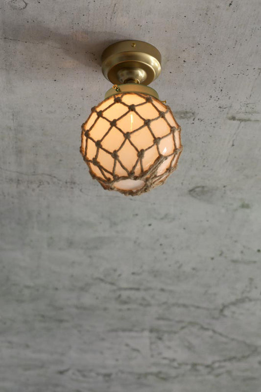 Opal glass ball shade with rope detail on a gold/brass batten holder. 