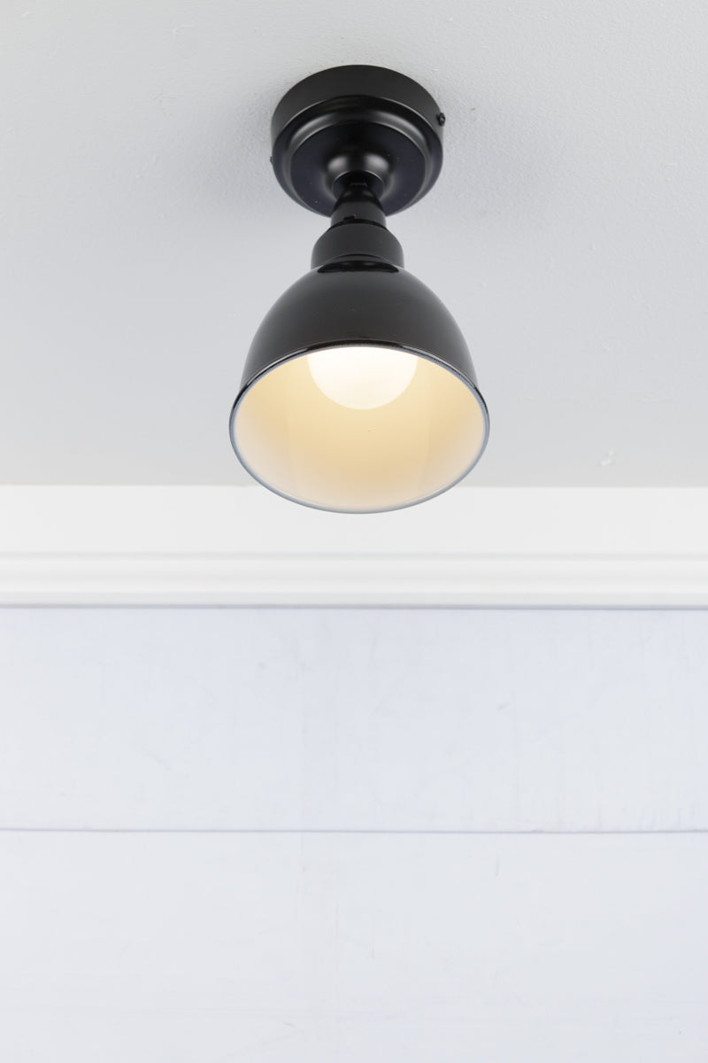 Black dome pendant flush mount light from below. 