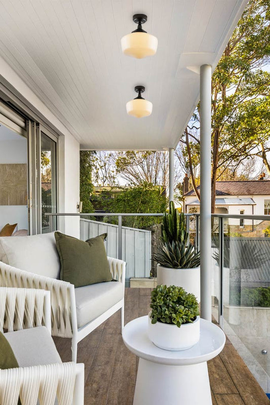 Two outdoor washington opal shades under a porch with IP rated black batten holders. 