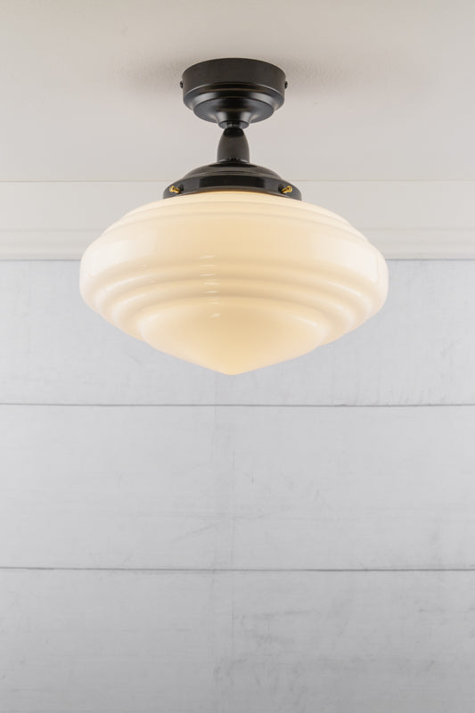 Schoolhouse style opal shade on an IP rated flush mount fixture. 