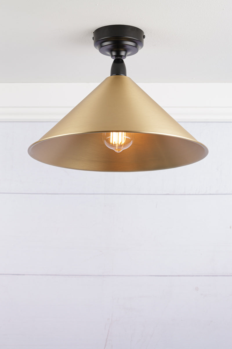 Large bright brass cone shade on a black IP rated battenholder.