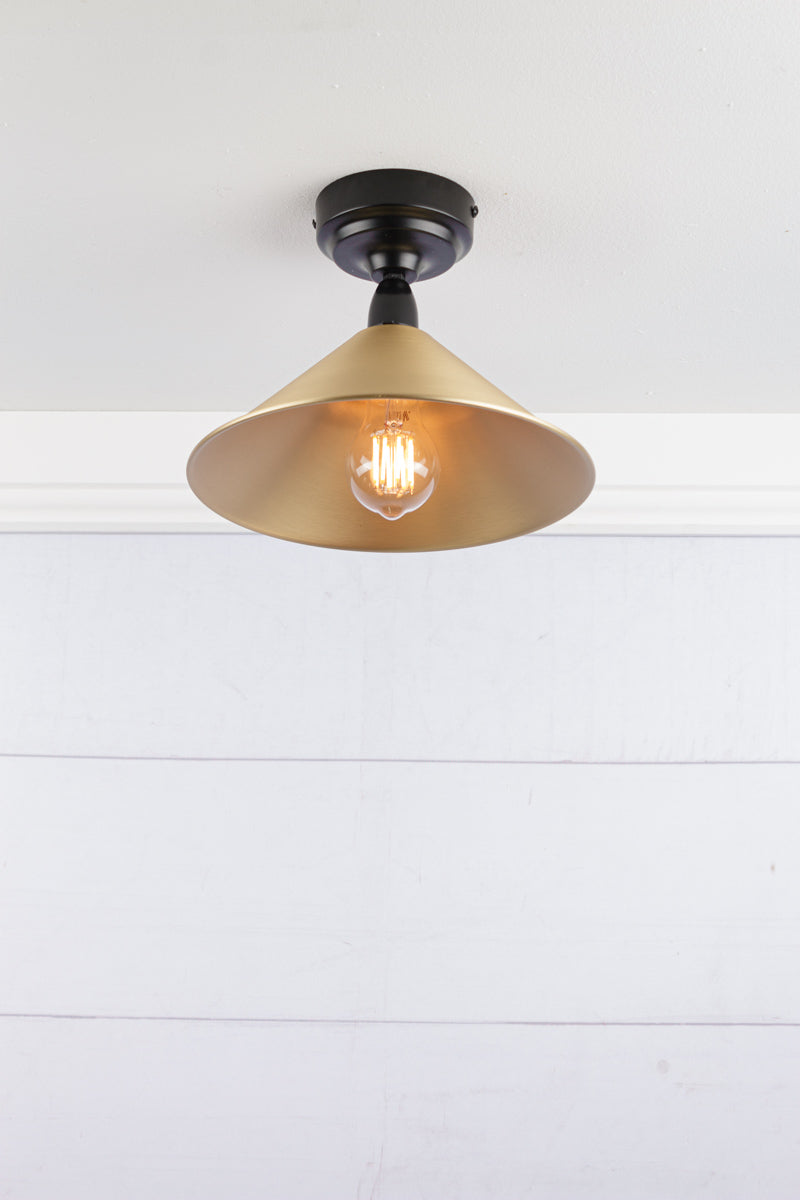 Small bright brass cone shade on a black IP rated battenholder.