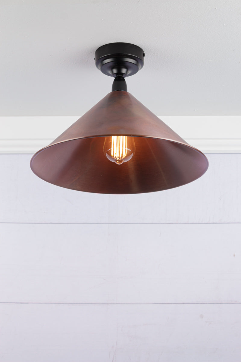 Large aged brass cone shade on a black IP rated battenholder.