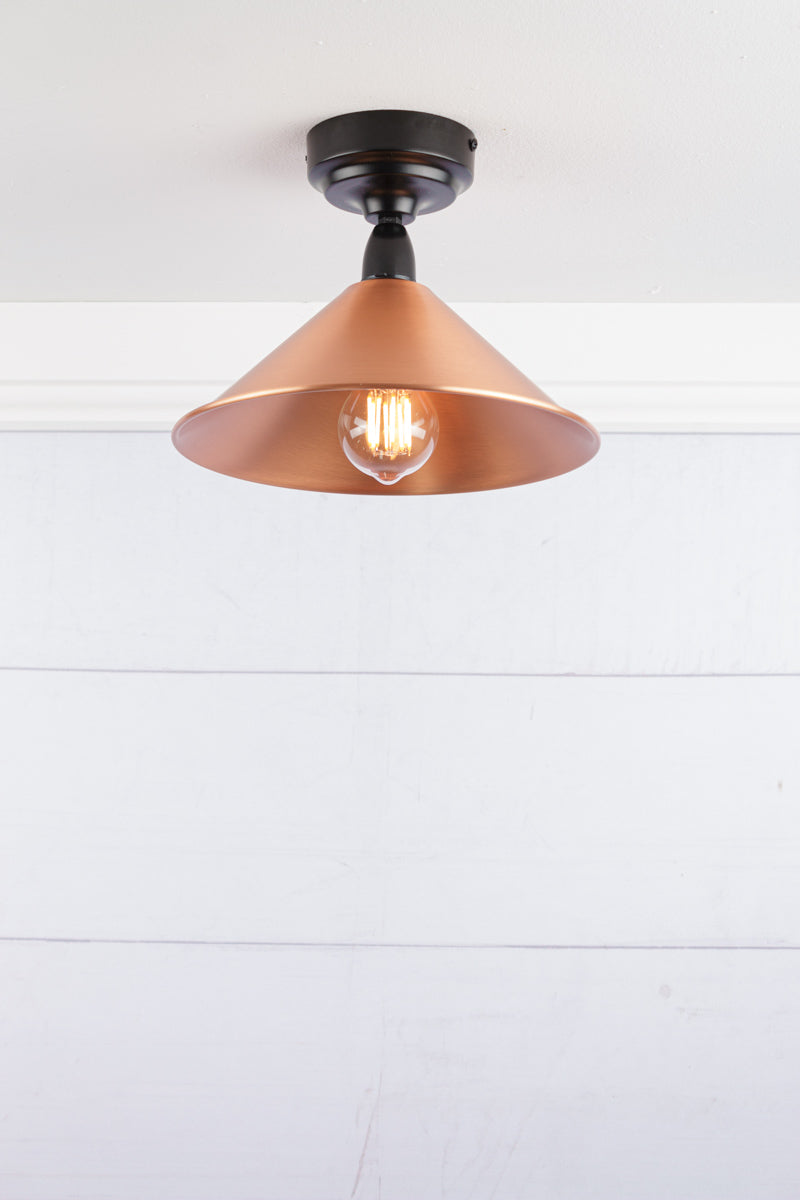 Small bright copper cone shade on a black IP rated battenholder.