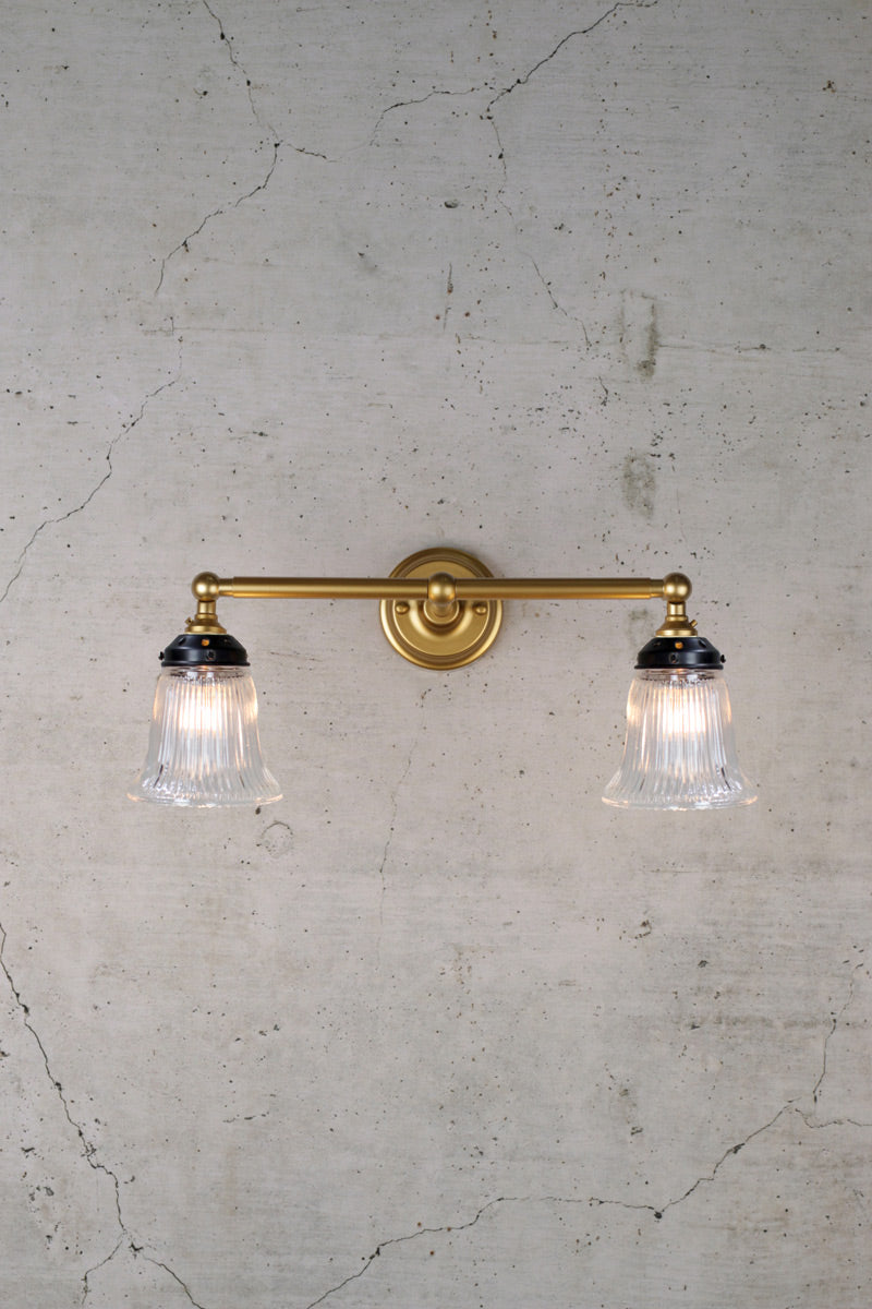 Gold double arm wall light with clear glass shades