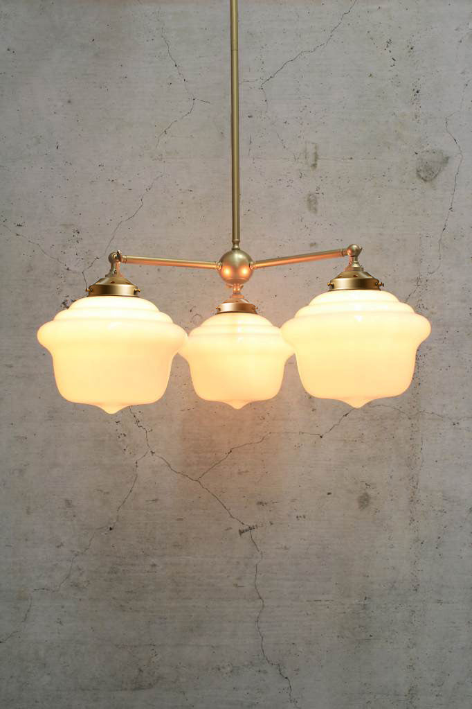 Three arm gold/brass chandelier with chicago schoolhouse style shades in opal. 