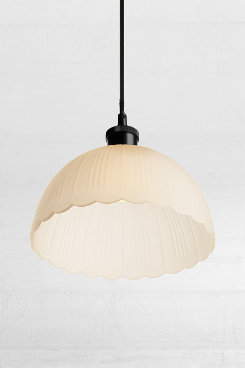 The glass shade is suspended from a braided cloth cord. Provides diffused lighting through its frost glass shade 