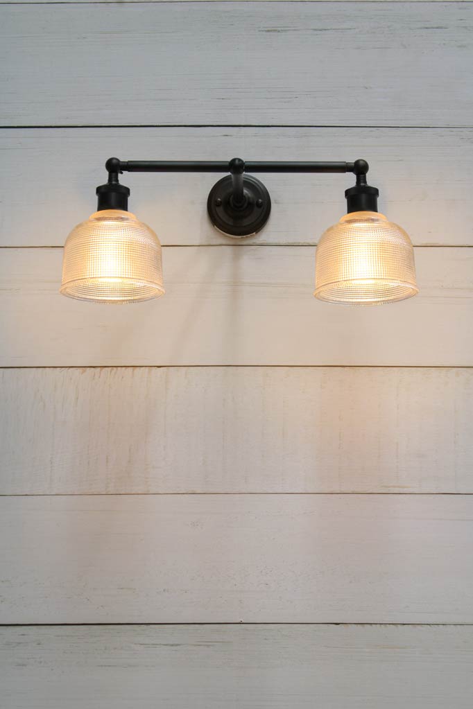 Black wall light with two holophane glass shades