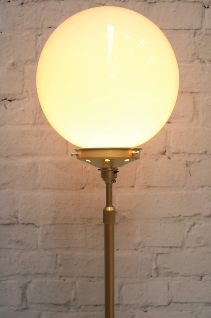 Close up of Medium opal glass ball shade on a gold/brass lamp stand