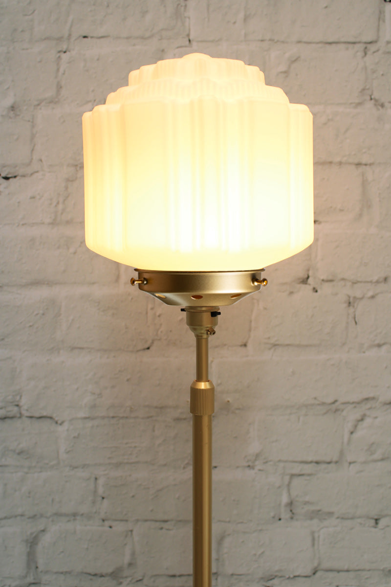 Close up of the Deco schoolhouse shade on a gold/brass candlestick floor lamp. 