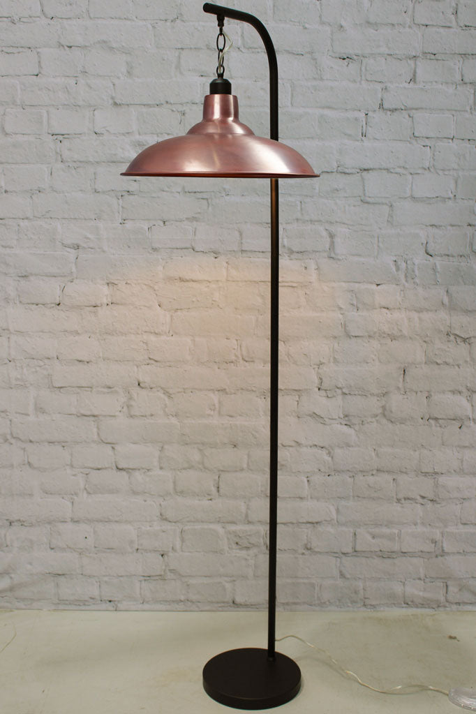 floor lamp with suspended aged solid copper finish shade and black stand.