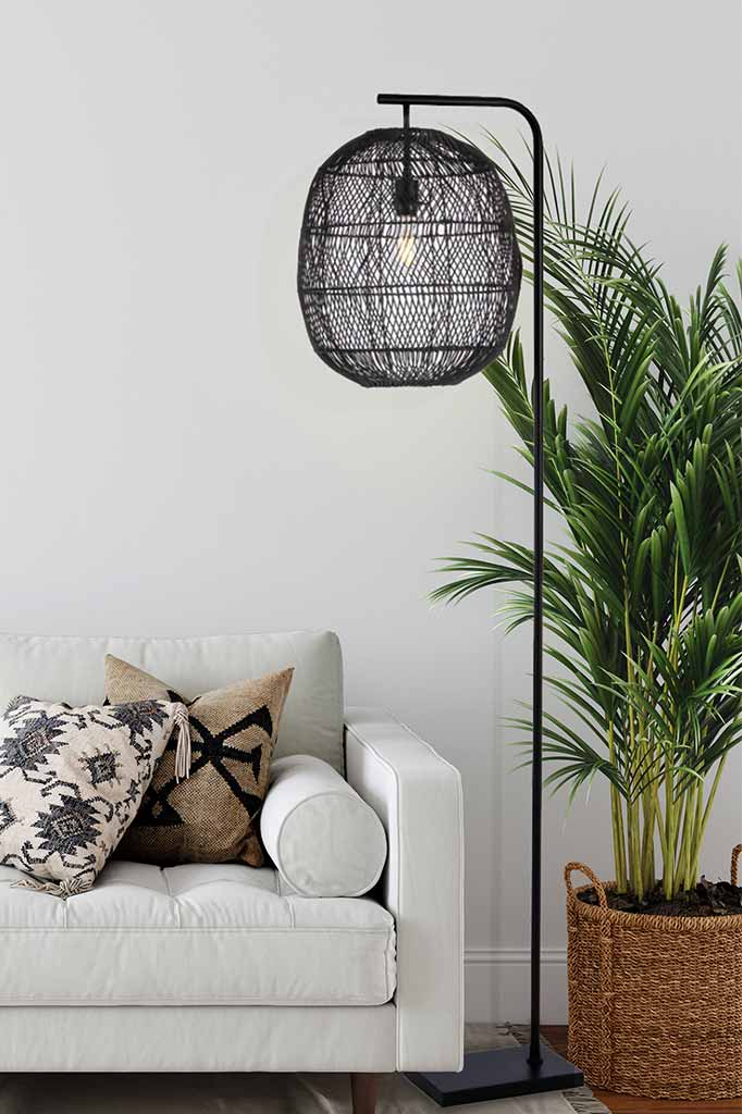 Rattan floor lamp in black finish in a living room