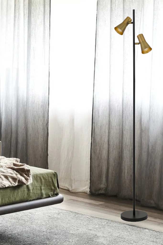 Pannal Floor Lamp with brass shades in a bedroom..