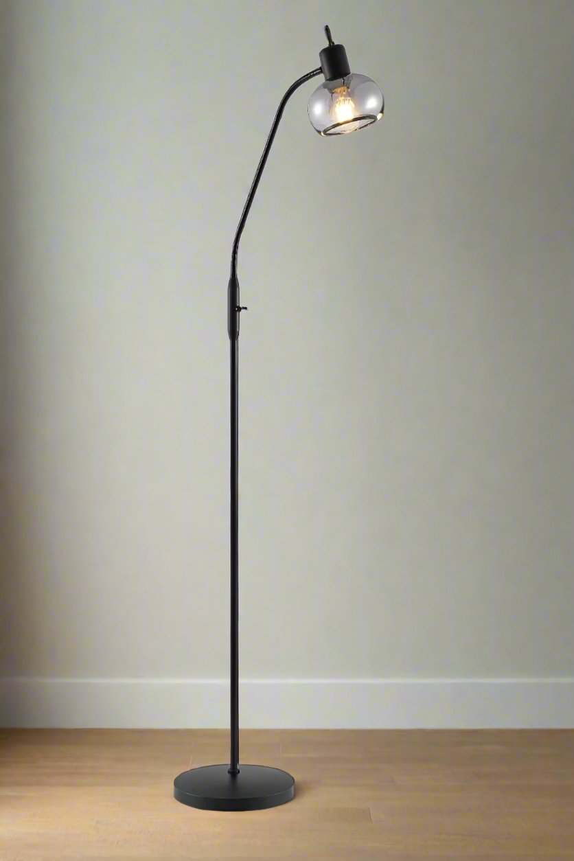 Black floor lamp with smoked glass shade on a timber floor