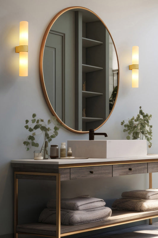 Two Cheswick vanity lights hanging next to a large circle mirror in a bathroom. 