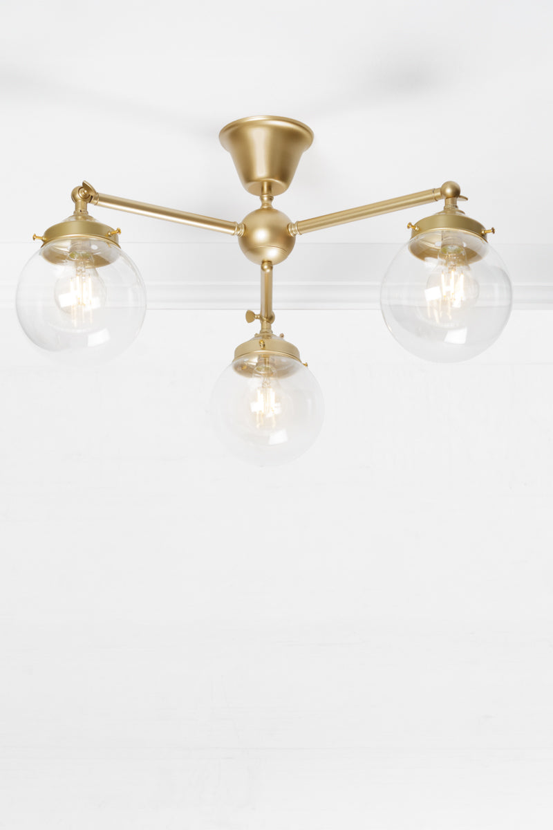 Medium Glass ball shades in clear on a 3 arm brass/gold flush mount