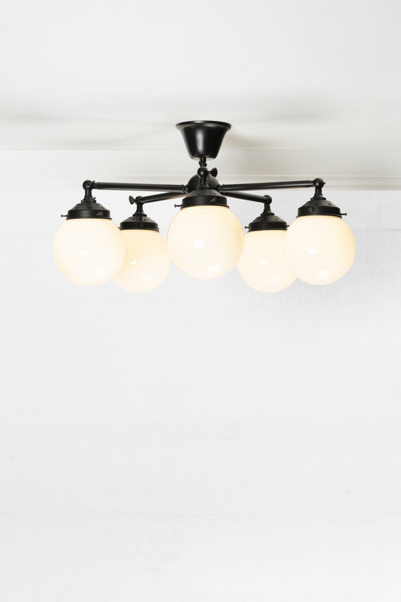 Small glass ball shades on 5 light black straight arm fixture.