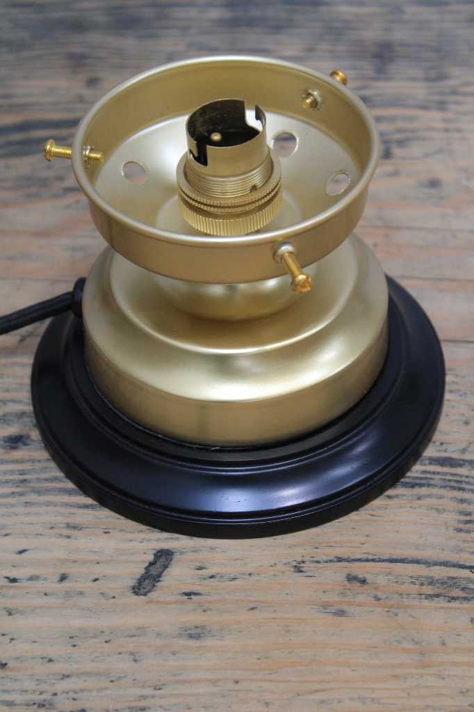 Gold/brass lamp bass with a black mounting block.