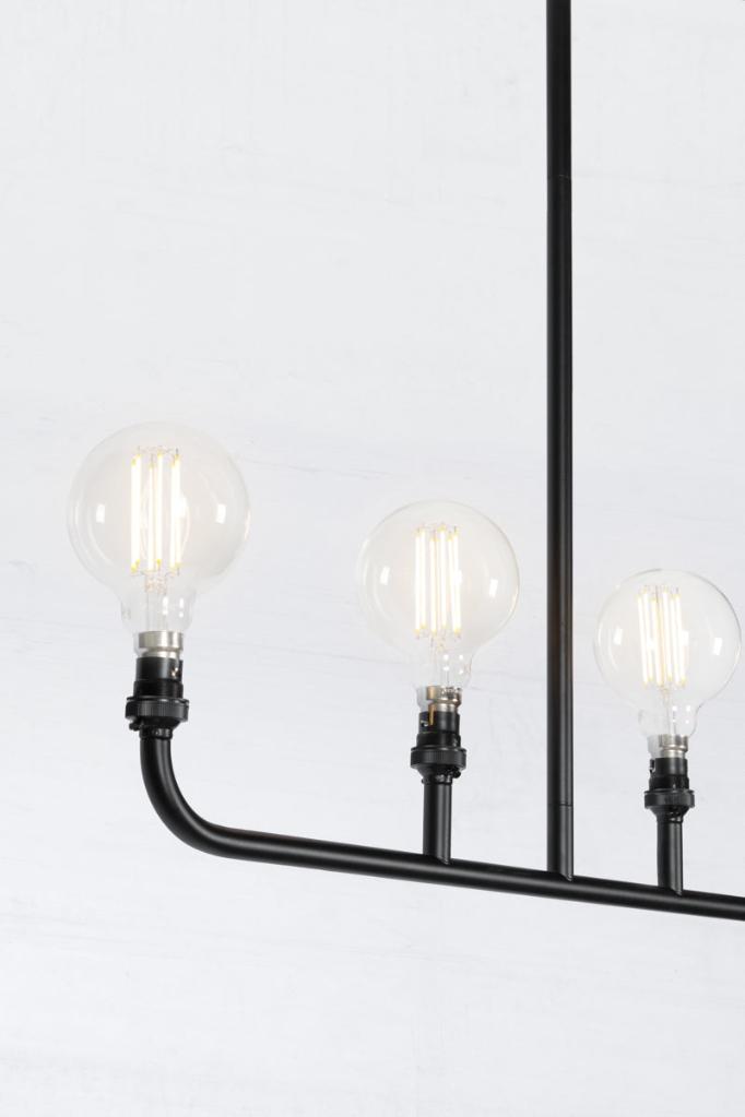 Close up of the Five lamp linear chandelier in black. 