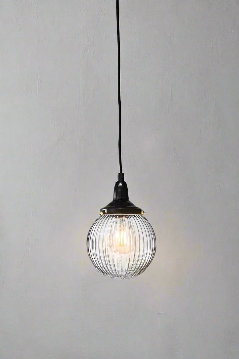 Clear reeded glass ball shade on a black IP rated pendant cord.