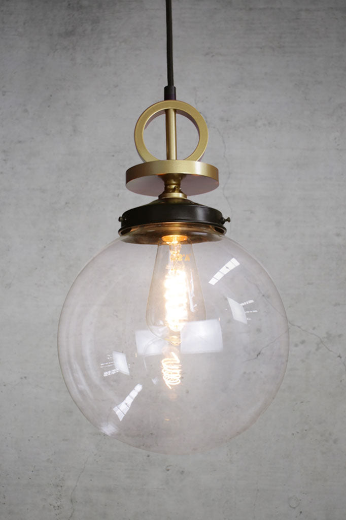 Medium clear glass pendant with gold brass disc cord