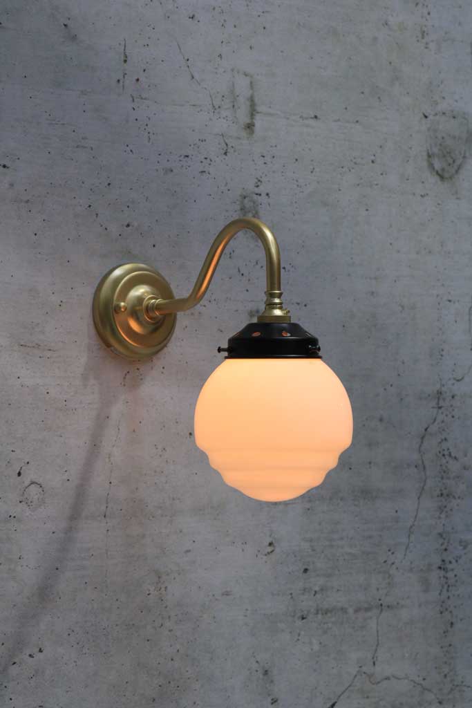 Gold/brass wall light with rippled opal shade