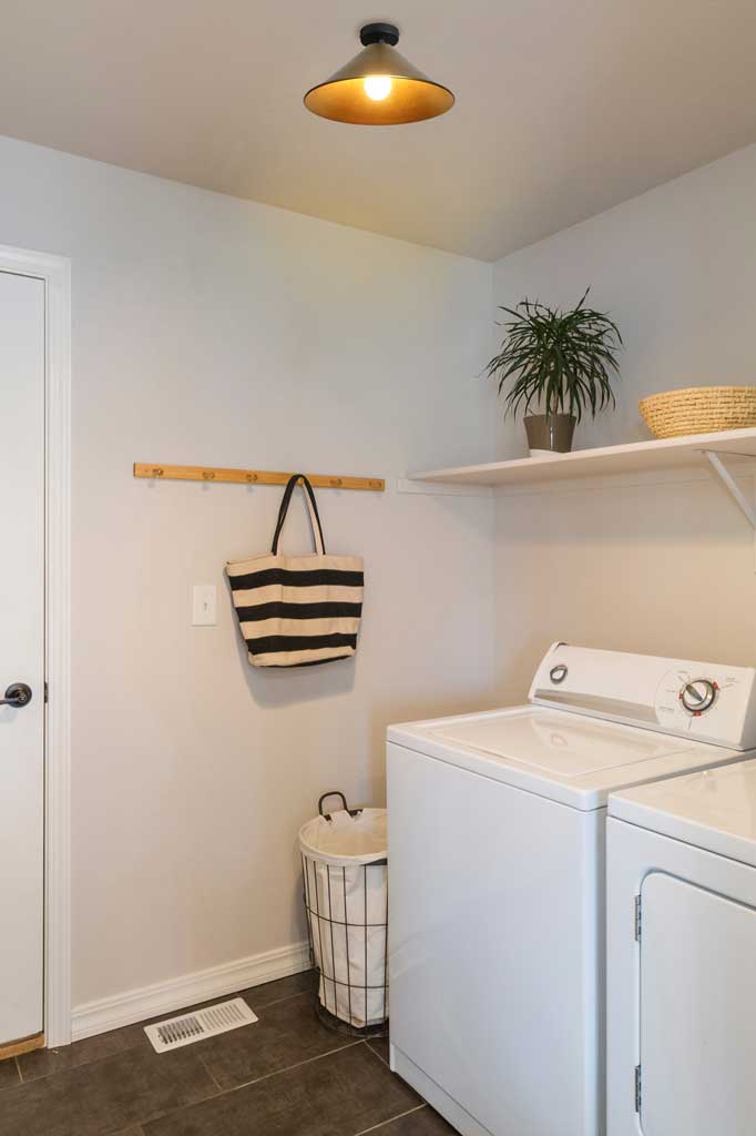 Brass cone flush mounted ceiling light in a bright laundry. 