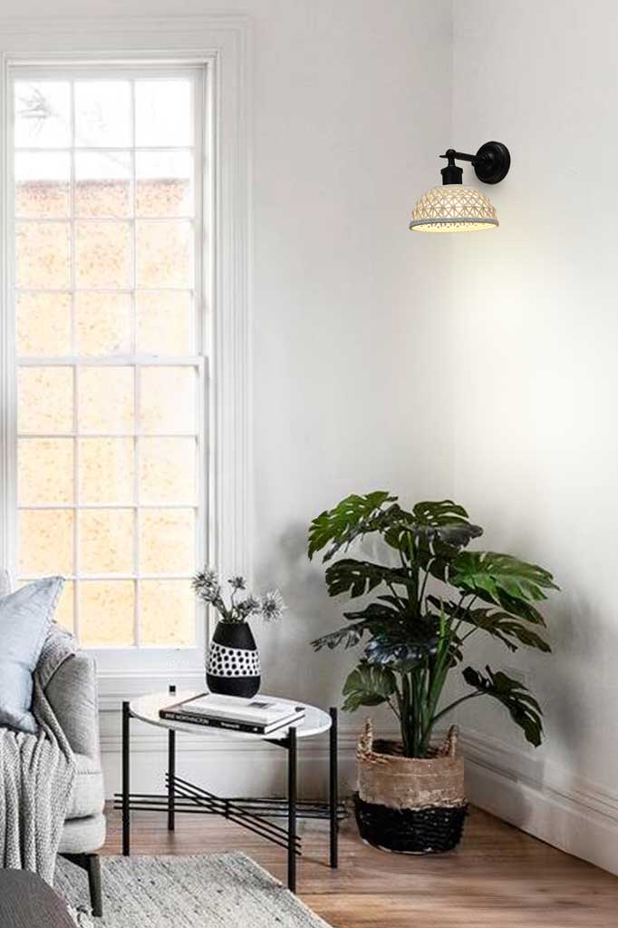 Short basket weave look ceramic shade hanging on a black straight arm in a bright white room. 