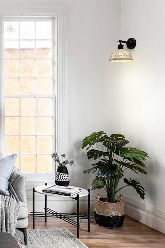 Short basket weave look ceramic shade hanging on a black straight arm in a bright white room. 