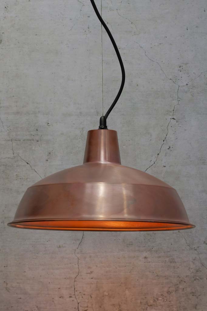 Large copper shade on a steel cable with black lampholder and cord. 