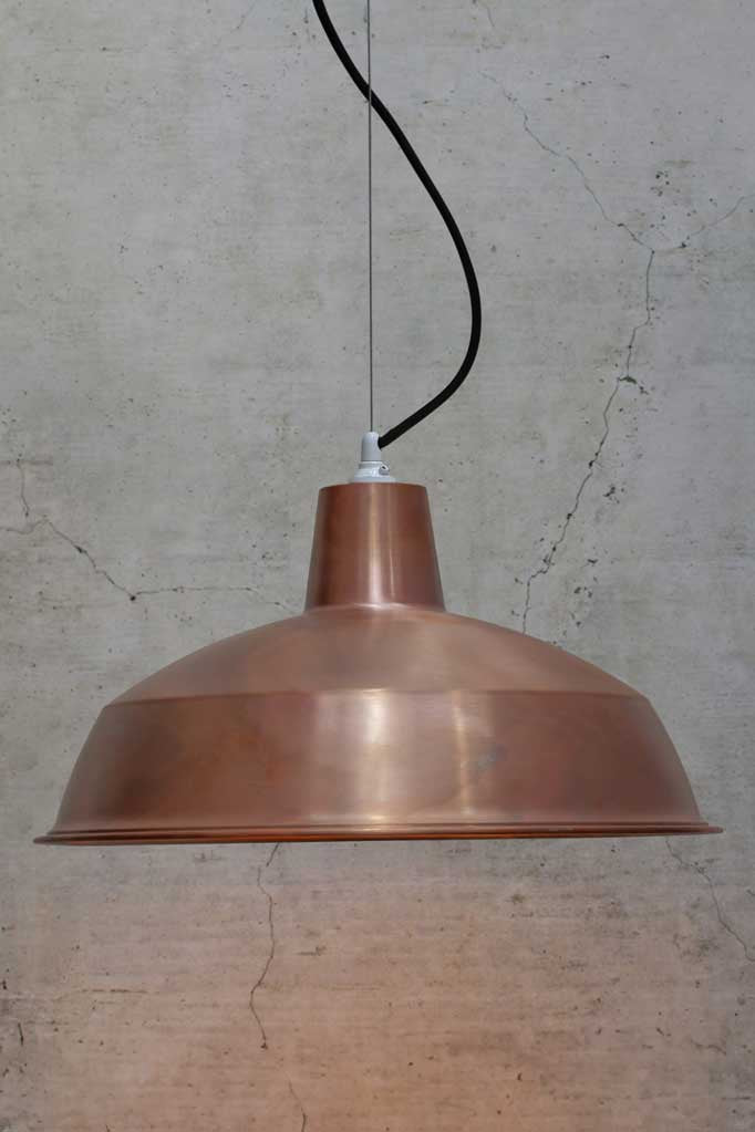 Large copper shade on a steel cable with white lampholder  and black cord. 