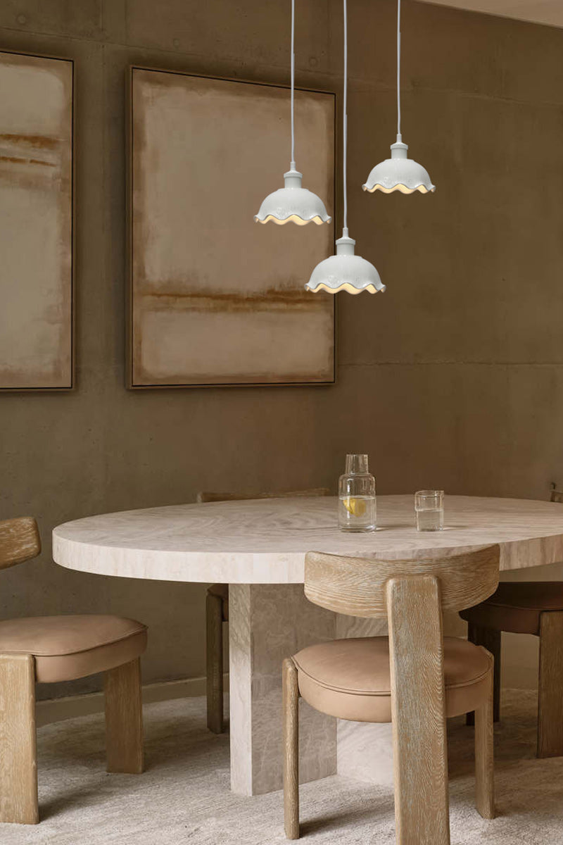 Three frilled ceramic pendants with white cord over kitchen table