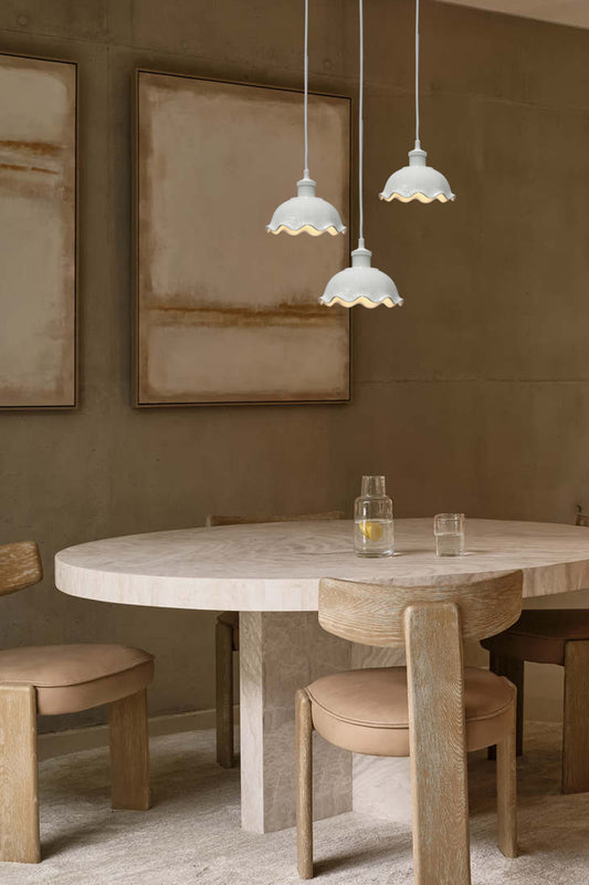 Three frilled ceramic pendants with white cord over kitchen table