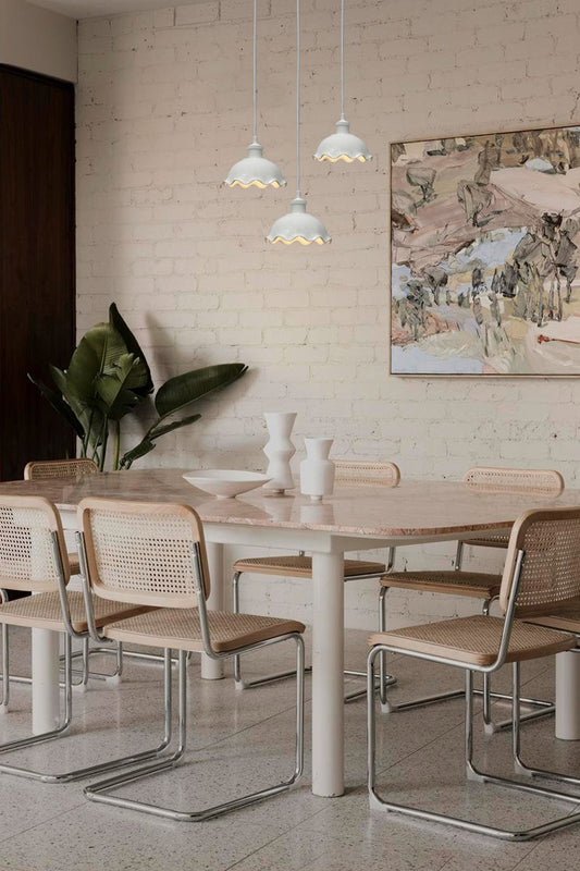 Three frilled ceramic pendants with white cord over kitchen table