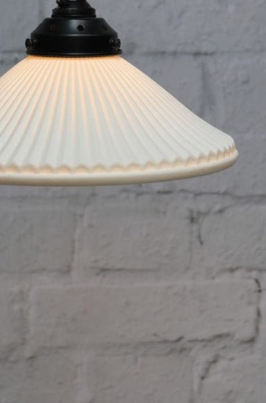 Ceramic shade on black pole pendant light