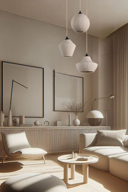 Three linen covered glass pendants with black metalware in a loungeroom