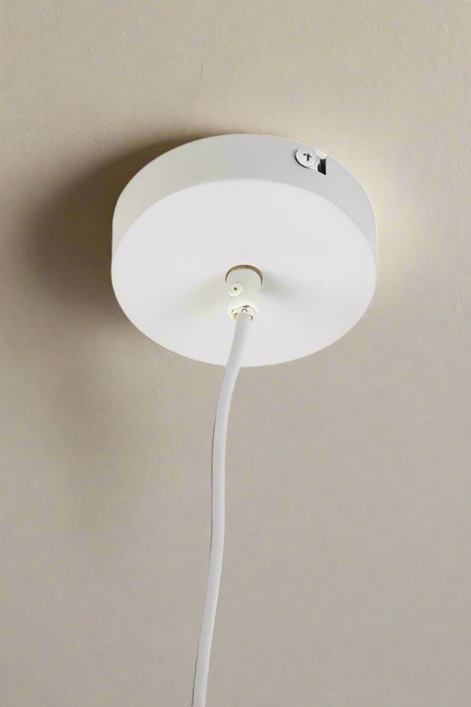 Close up of white ceiling rose and cord