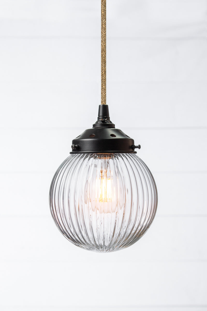 Clear reeded glass ball shade on a jute pendent cord with black metalware. 