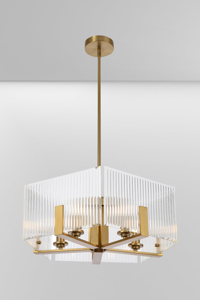 Angled view of a Antique Gold pentagon shaped chandelier frame with reeded glass panels. 