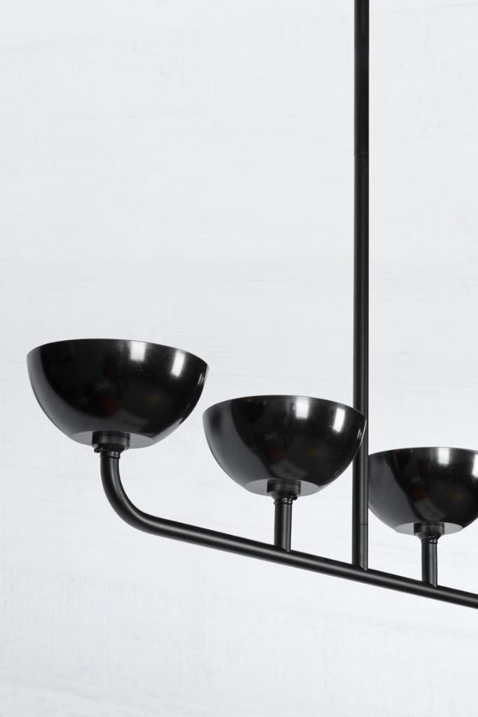 Close up of the black 5 light linear chandelier with black Bakelite shades. 