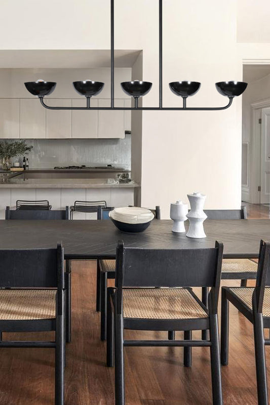 Five light bakelite linear chandelier over a dining space. 