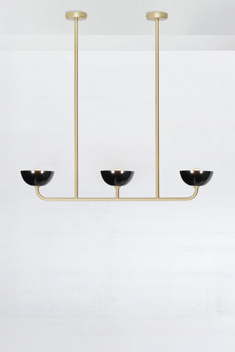 Gold/brass triple light linear chandelier with black Bakelite shades. 