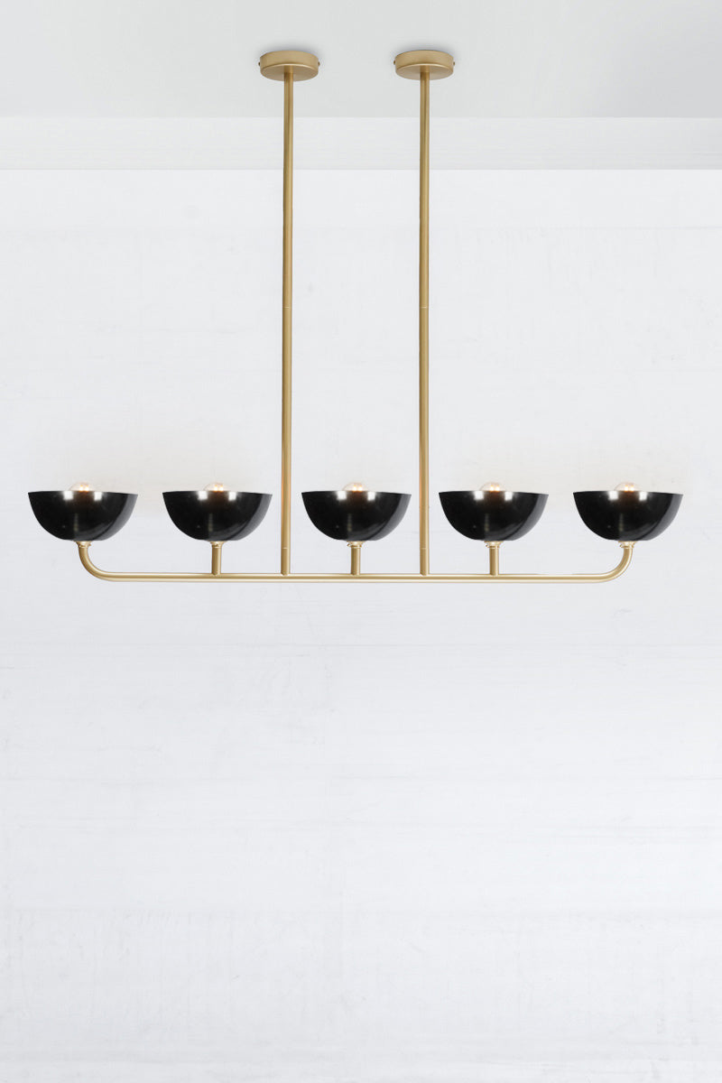 Gold/brass five arm light linear chandelier with black Bakelite shades. 