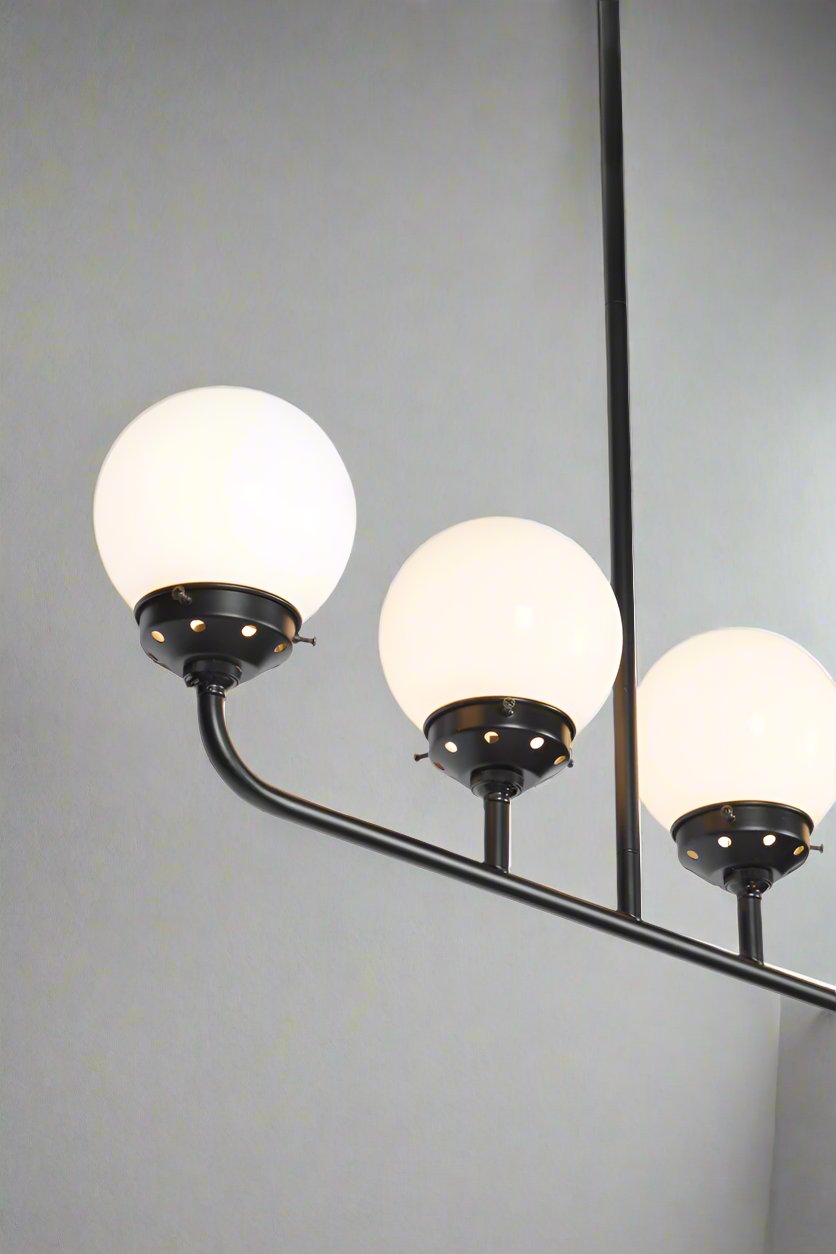 Close up of the Five lamp linear chandelier with opal glass ball shades