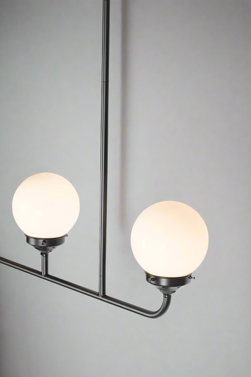 Close up of the triple lamp linear chandelier with opal glass ball shades