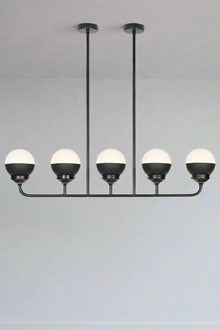 Crown sphear shades on a five lamp linear black chandelier. 